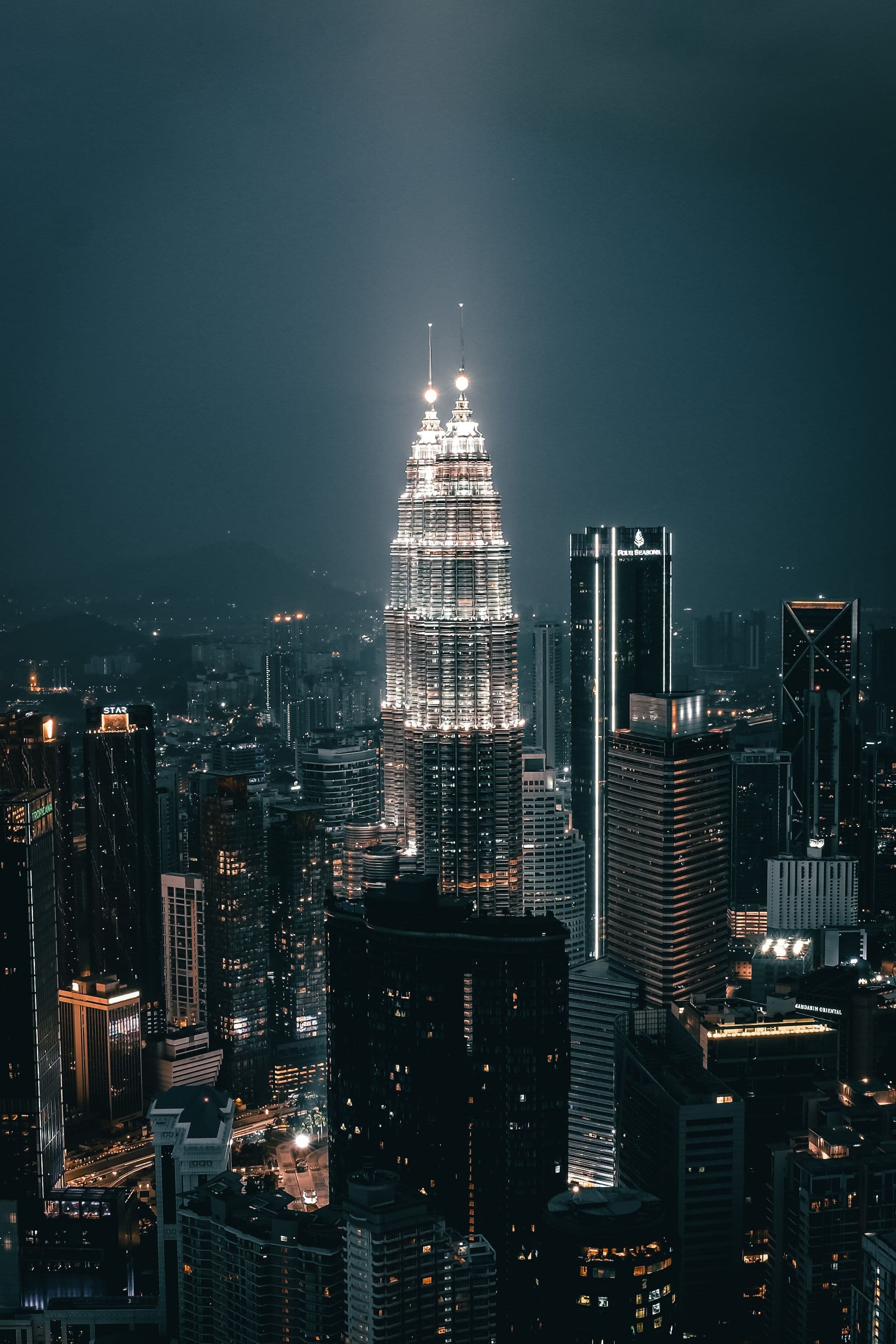 A breathtaking night view of Kuala Lumpur's skyline showcasing the illuminated Petronas Twin Towers